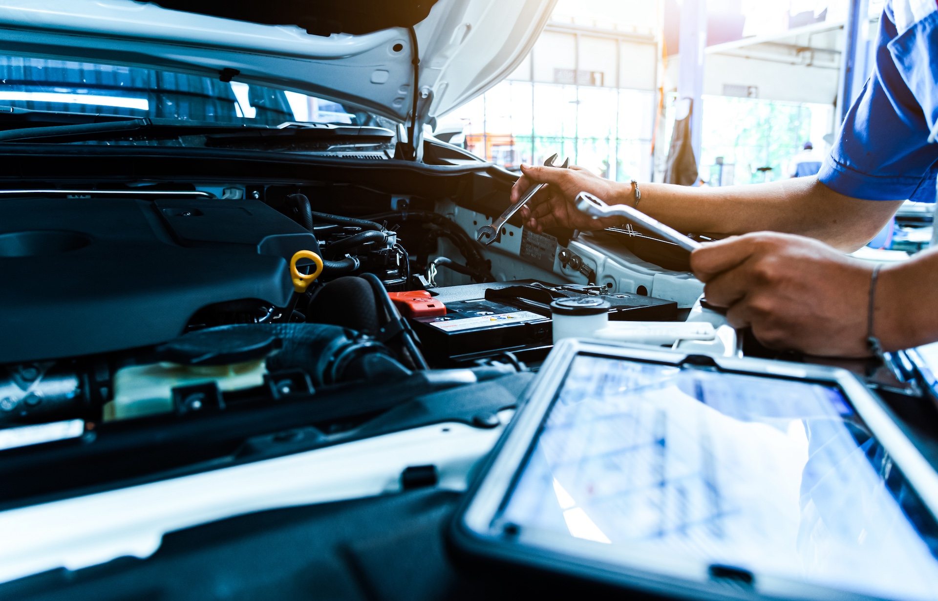 Auto mechanic checking the condition of the car. The technician uses the tablet to check.