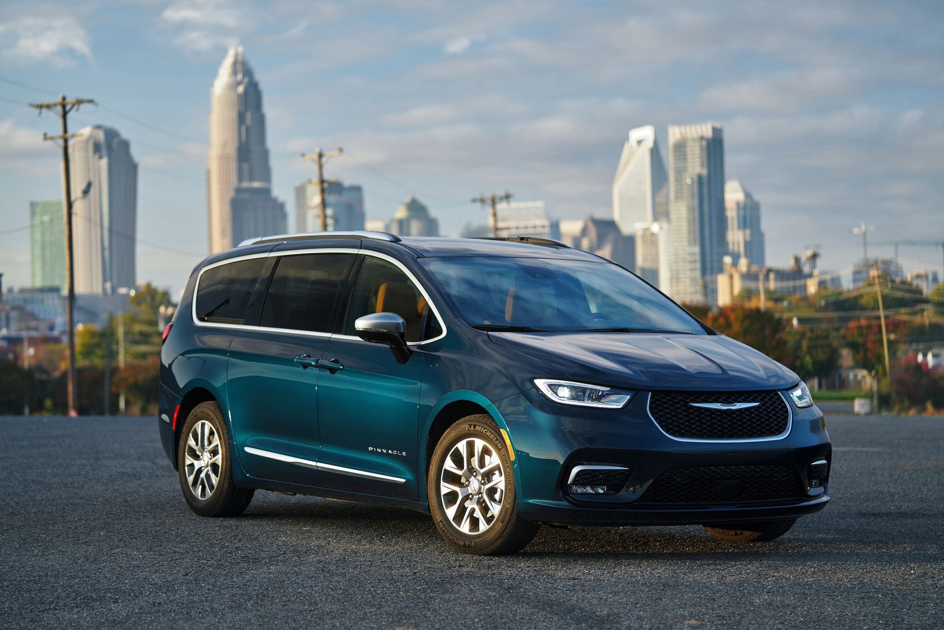 2025 blue Chrysler Pacifica backed by urban cityscape