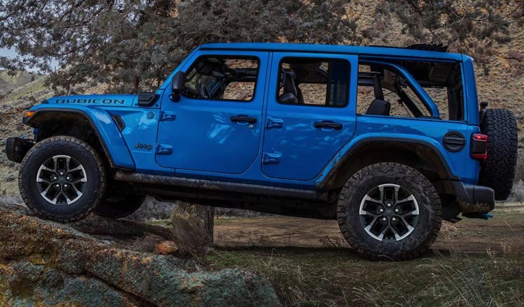 Blue Jeep Wrangler going up the terrain