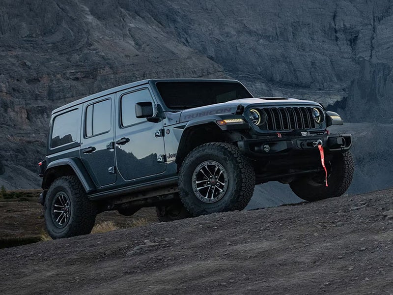 Dark Blue Jeep Wrangler driving up a hill